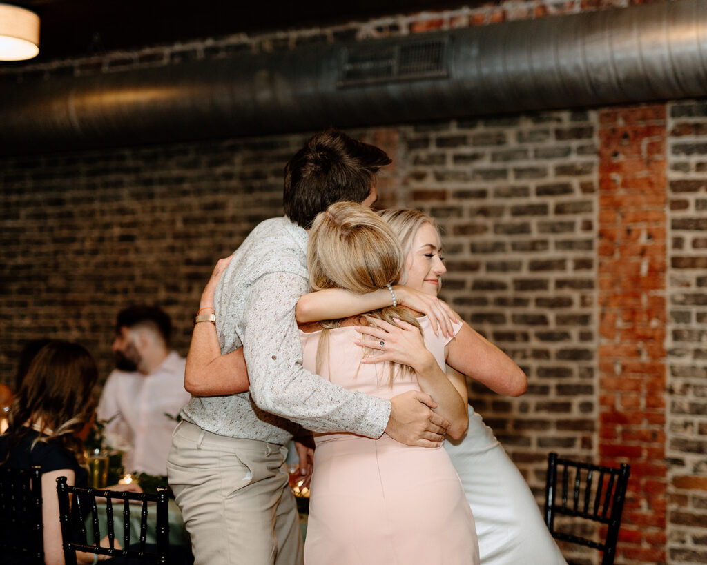 three people in a group hug
